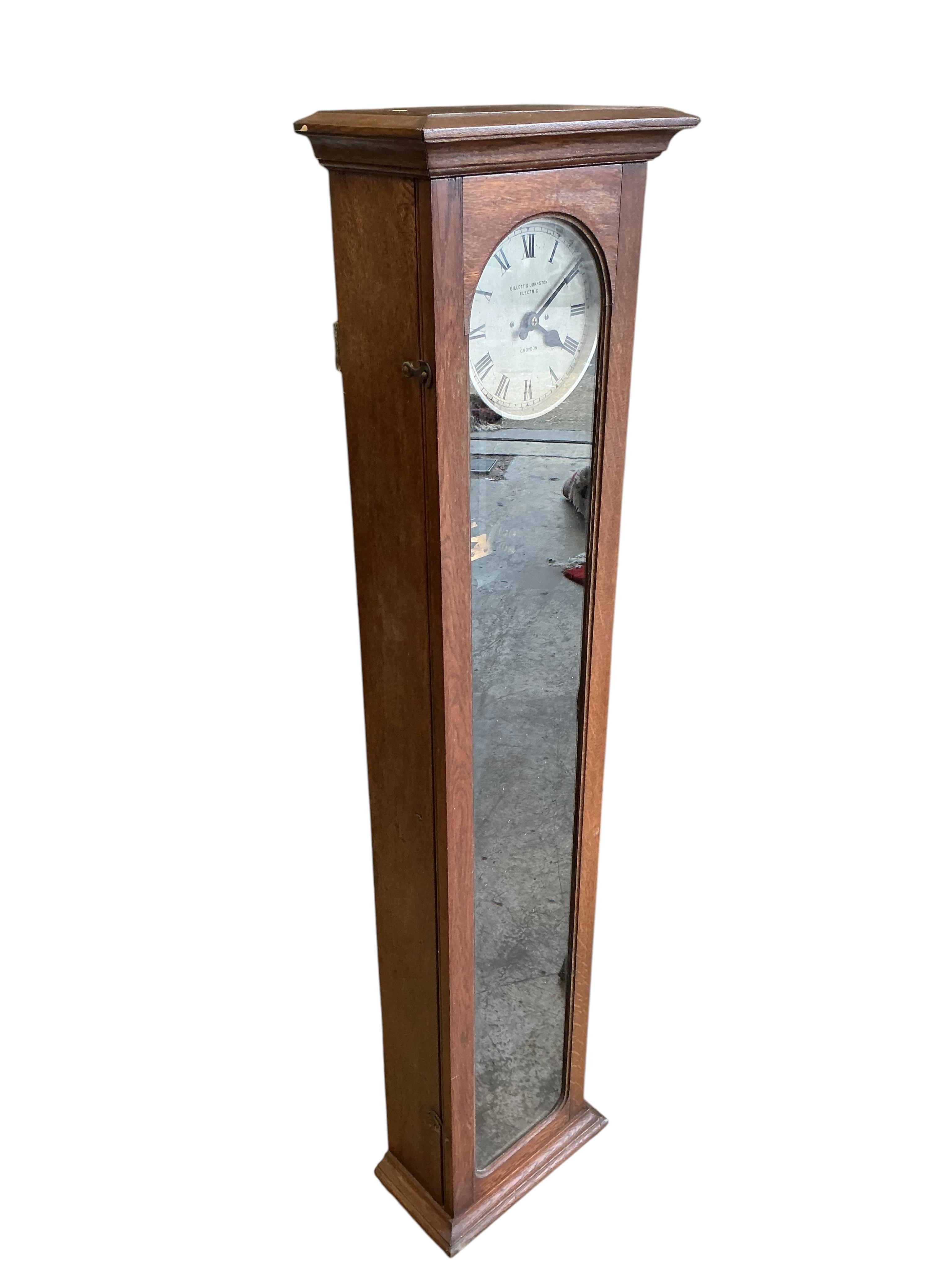 A Gillett & Johnston oak cased electric Master wall clock, with pendulum, height 139cm